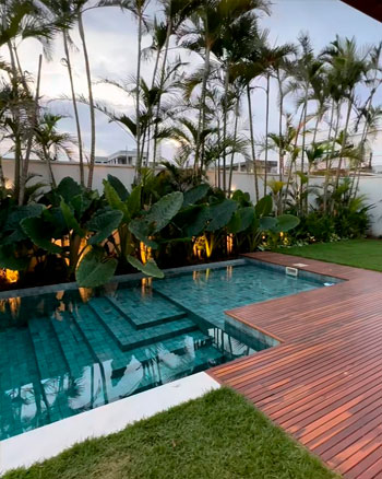 Sukabumi green stone tiles for swimming pools combined with wooden flooring for tropical gardens.